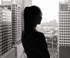 Woman look out of office window thinking.